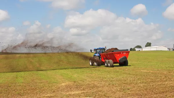 SL 124 distribuant du fumier dans un champ.